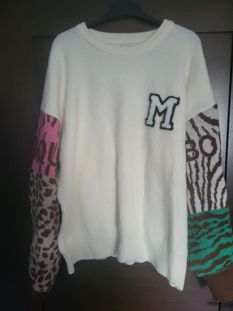 Sweter kremowy z naszywką „M” – wzorzyste rękawy 1606