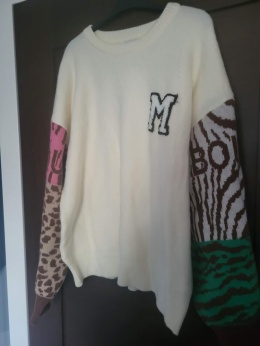 Sweter kremowy z naszywką „M” – wzorzyste rękawy 1606